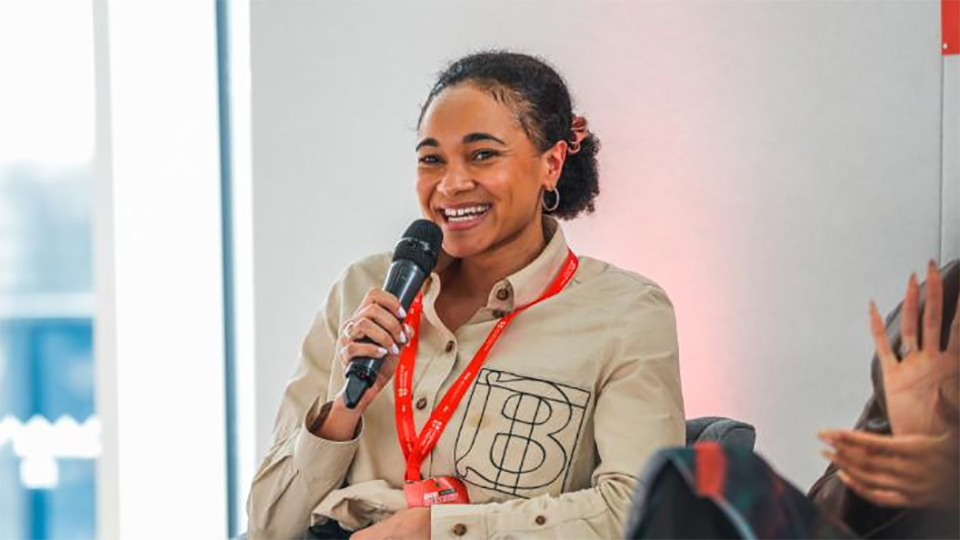 Alice Dearing holding a microphone and smiling