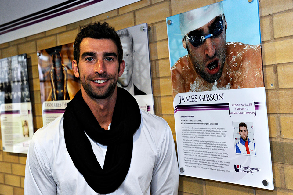 James Gibson stands next to his Hall of Fame image displayed on campus. Image taken in 2011.