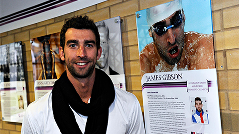 James Gibson stands next to his Hall of Fame image displayed on campus. Image taken in 2011.