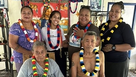 Six people in a group wearing garlands around their necks