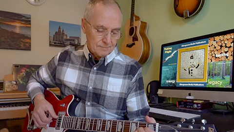 Alan Robertson playing a guitar