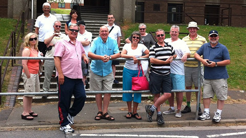 A group of Royce Hall alumni standing in front of some concrete steps.