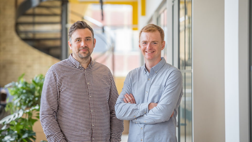 Pete Sisson and Paul Humphreys standing together smiling