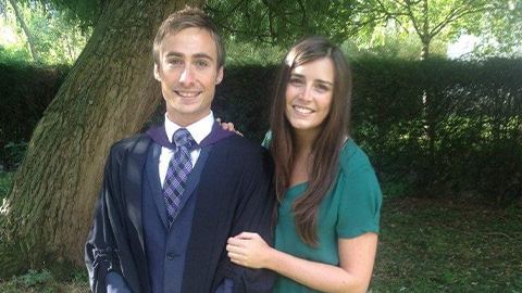 Jonathan and girlfriend standing smiling at Jonathan's graduation