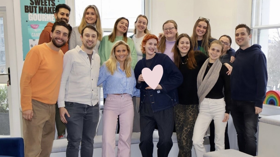 A group photo of people standing, taken indoors