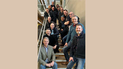 A group of alumni standing on a stair case