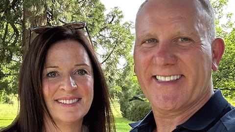 Martin Clay and Sharon Clay who are both Managing Directors of The Clay Advantage. They are standing together and they are smiling. There are trees in the background.