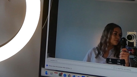 A ring light and a computer screen
