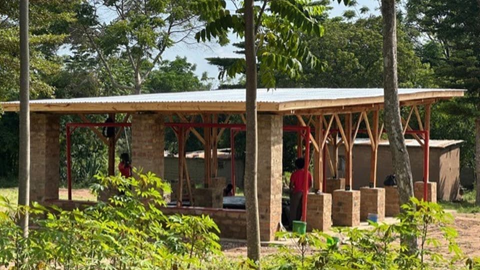 A building with pillar style structure surrounded by trees