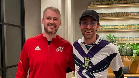 Two people wearing sports clothes, smiling.