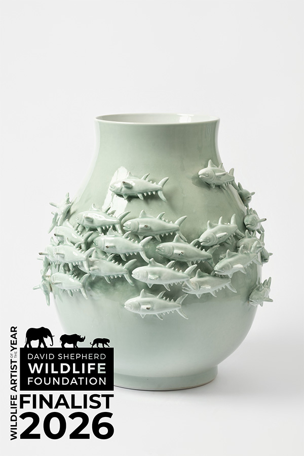 Pale green ceramic vase decorated with three-dimensional fish swimming around the body of the vessel, shown against a light grey background. David Shepherd Wildlife Foundation Wildlife Artist of the Year 2026 Finalist logo appears in the corner.