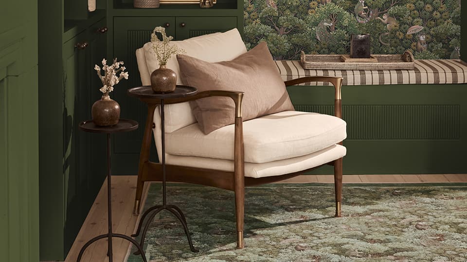 A green rug. There is a neutral chair and green flooring.