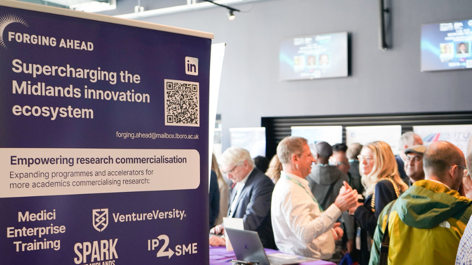 A crowd of people networking with a purple banner in the foreground that reads 'Forging Ahead'