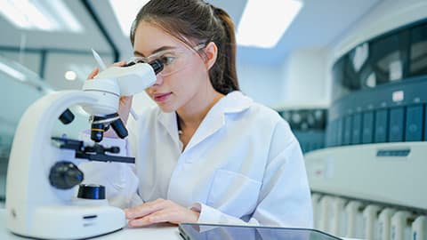A researcher looking into a microscope