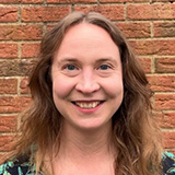 A head and shoulder shot of Rhianna Briars standing in front of a brick wall