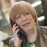 A head and shoulders shot of Sue Grogan on the telephone