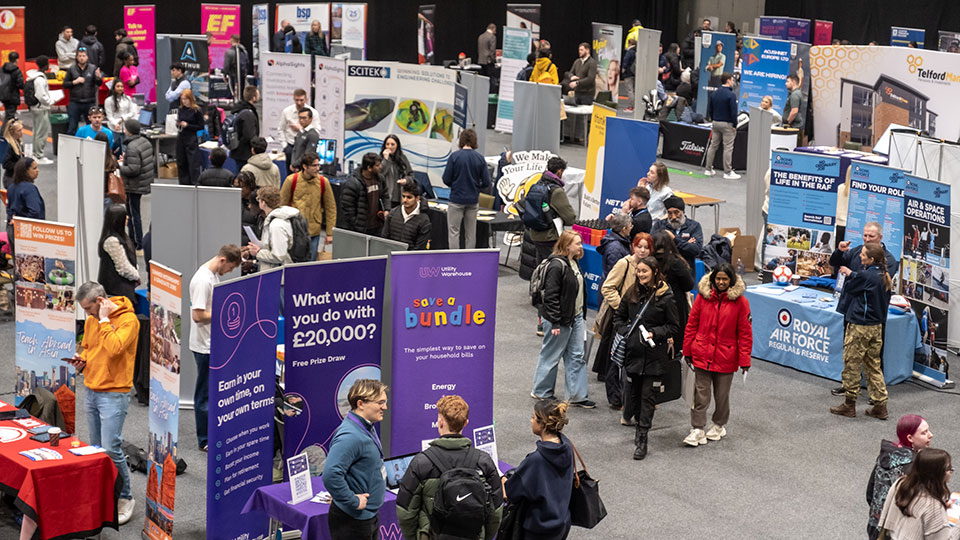 An aerial view of employer stands and students browsing the careers fair on campus