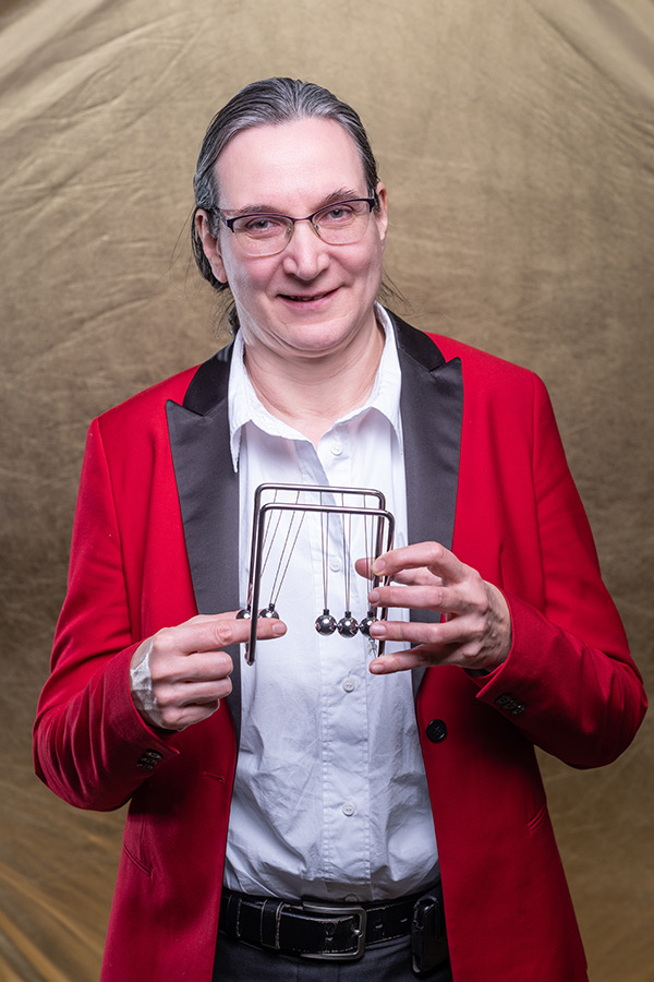 Professor Claudia Eberlein holding a Newton’s cradle. 