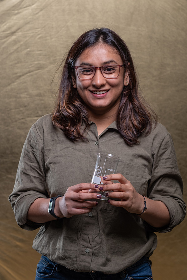 Neel Mehta stood holding a glass beaker in her hand. 