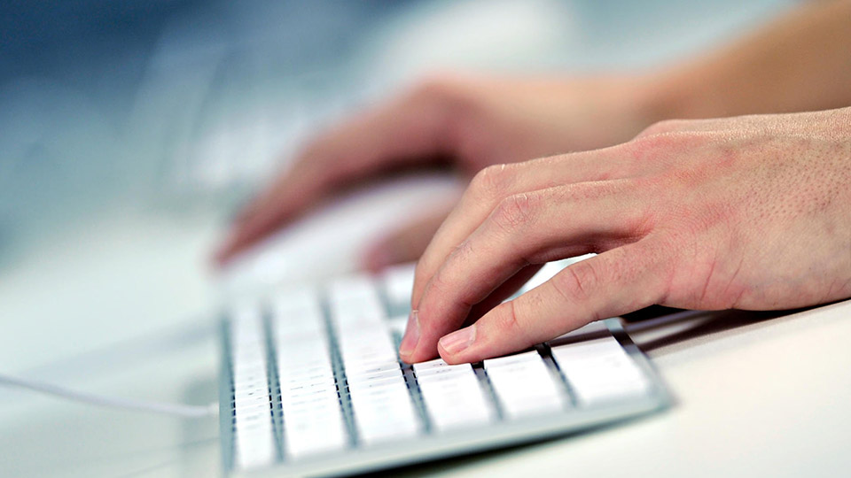 Generic image of someone typing on a keyboard, presumably sending an email.