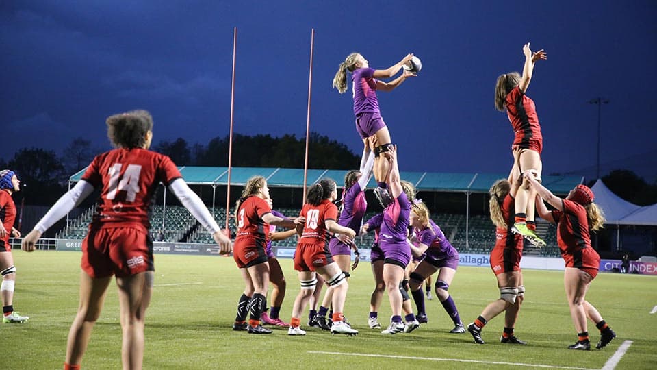 Women's Rugby Union match in progress with two players being held in the air