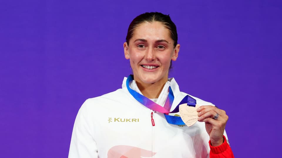 Imogen Clark with a silver medal, wearing a tracksuit top, smiling