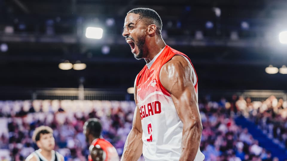 Jamell Anderson wearing an England sports top, celebrating on the basketball court