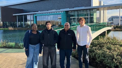 Four people standing in front of the MTC building