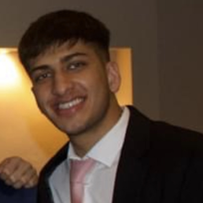 Sameer wearing a suit and smiling
