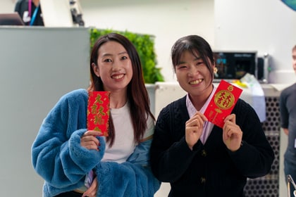 Two people holding red envelopes