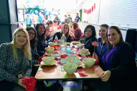 Smiling people sat at a table with food