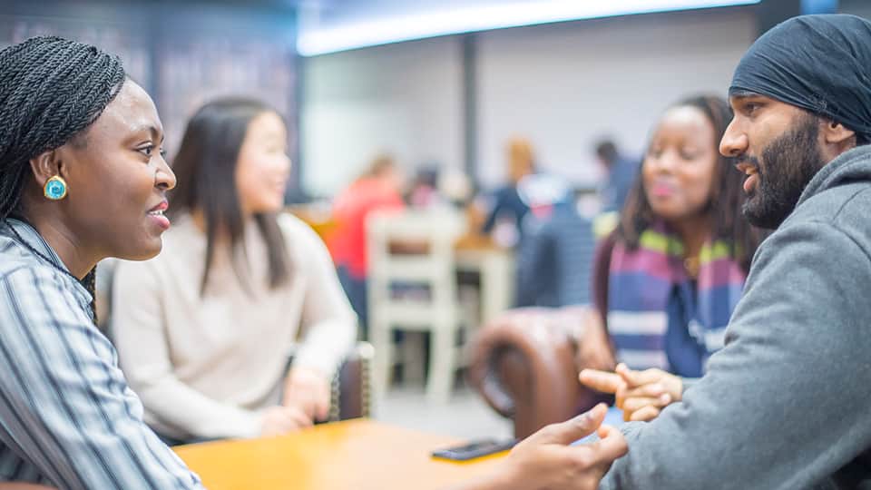 a group of people sitting around a table talking