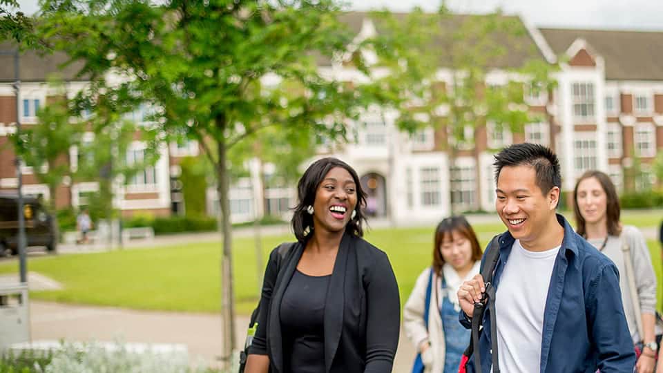 a group of four students walking on the campus