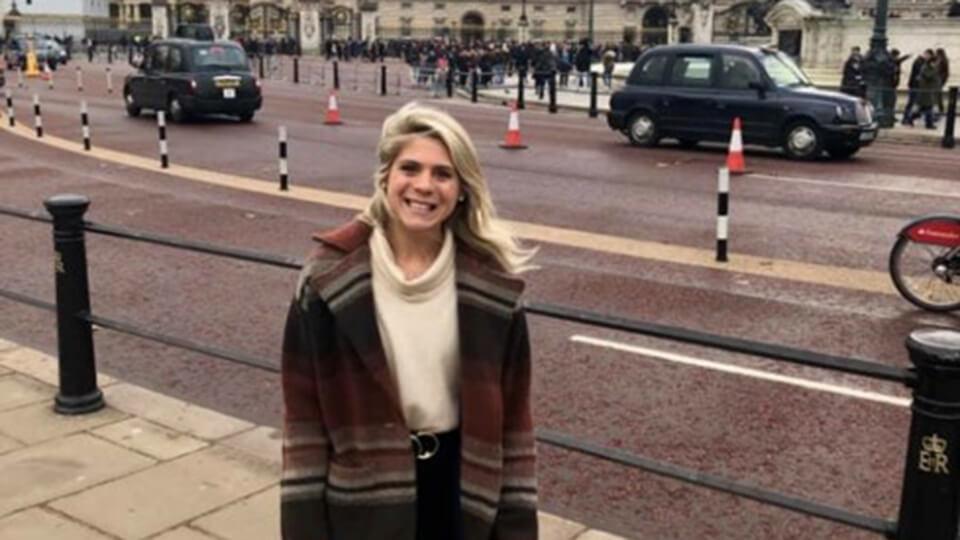 Postgraduate student smiling at camera on trip to Buckingham Palace