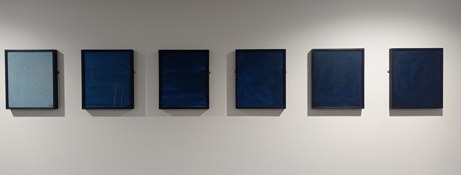 A series of six oil paintings in black frames. Running left to right they are in increasingly dark blues, depicting a descent underwater.