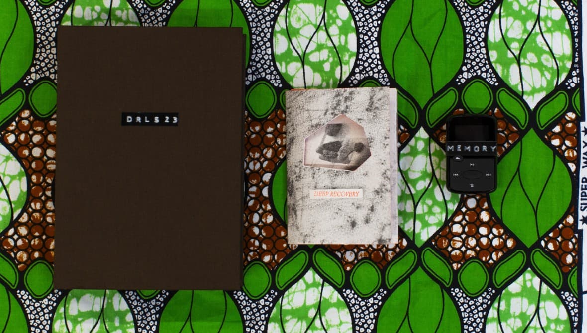 Two small books on an abstract green leaf background.