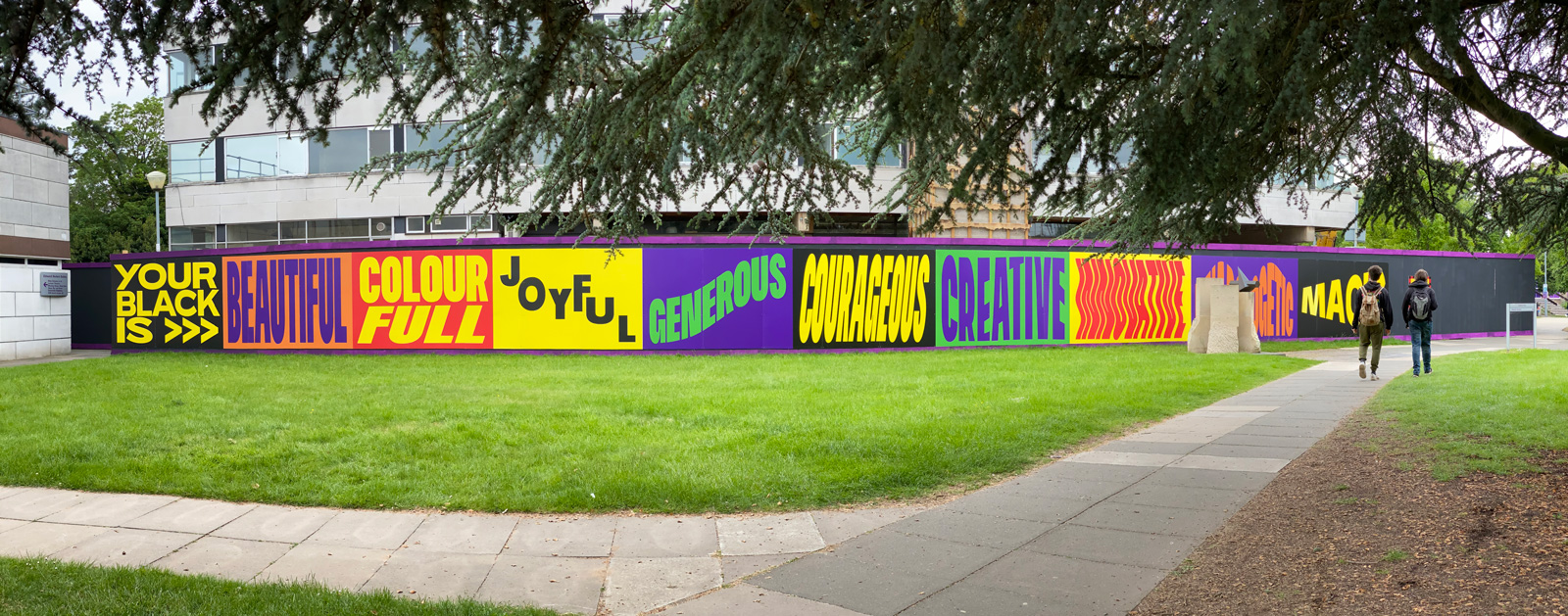A 30 metre wide mural installed on campus featuring graphic words and colourfully designed squares.