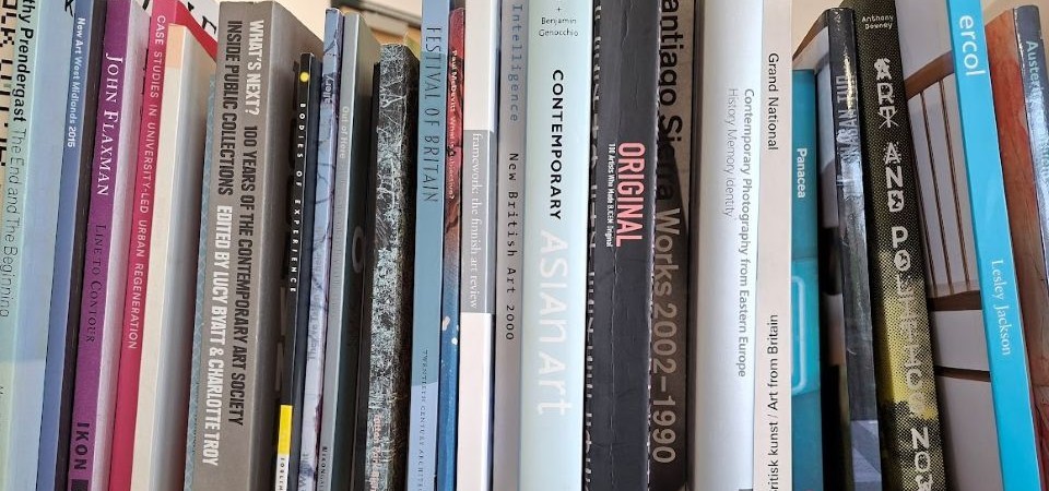 A row of books stood vertically side by side with the various book spines visible