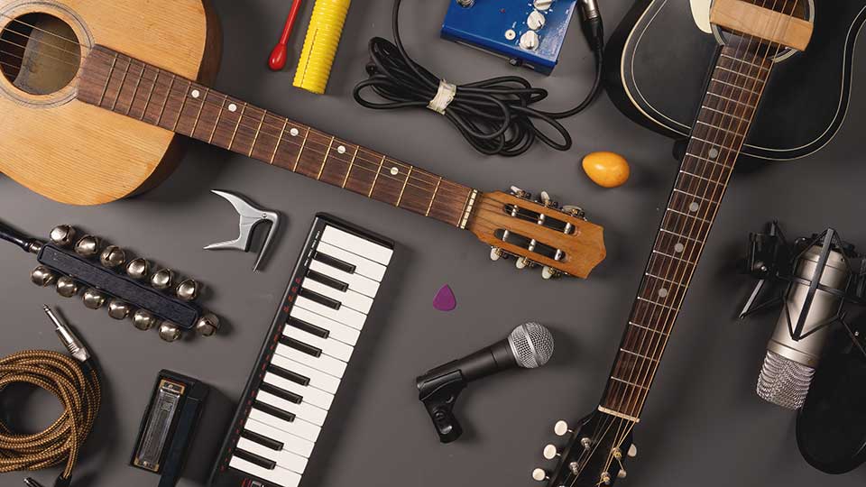 An overhead photograph of a large array of musical instruments on a dark grey background