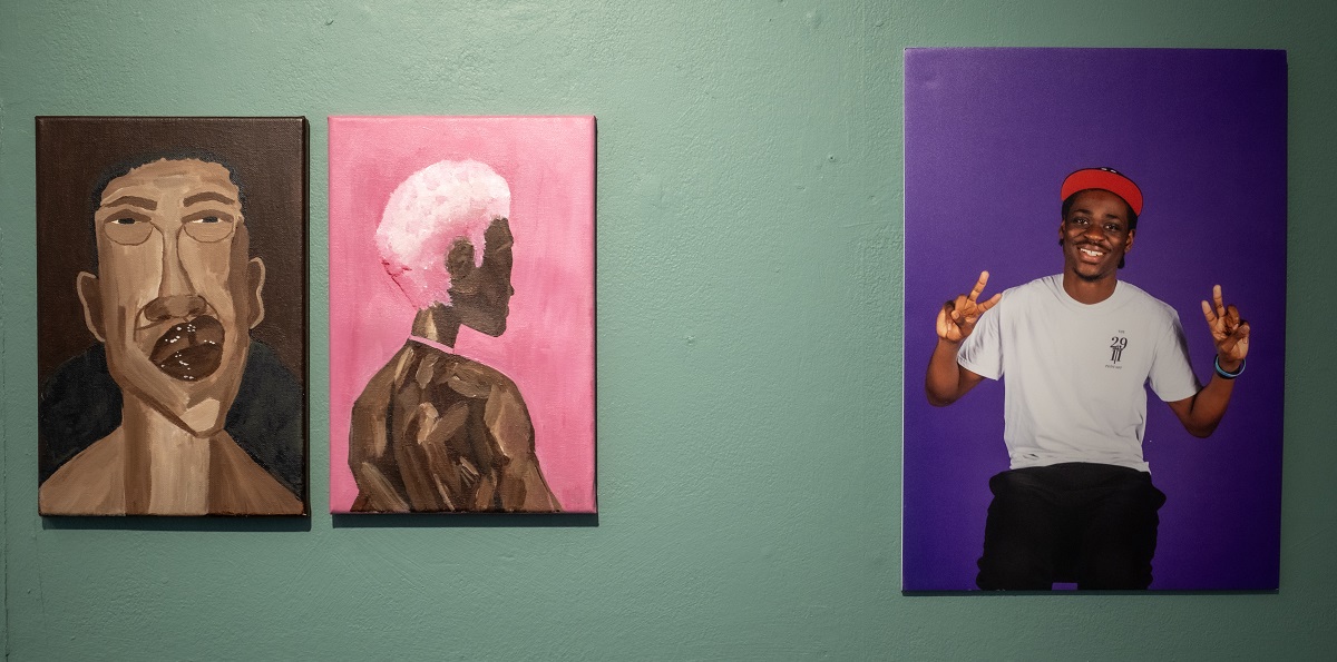 Three works, two painted black figures on the left and separate a photograph of a young black man with a cap on against a purple background