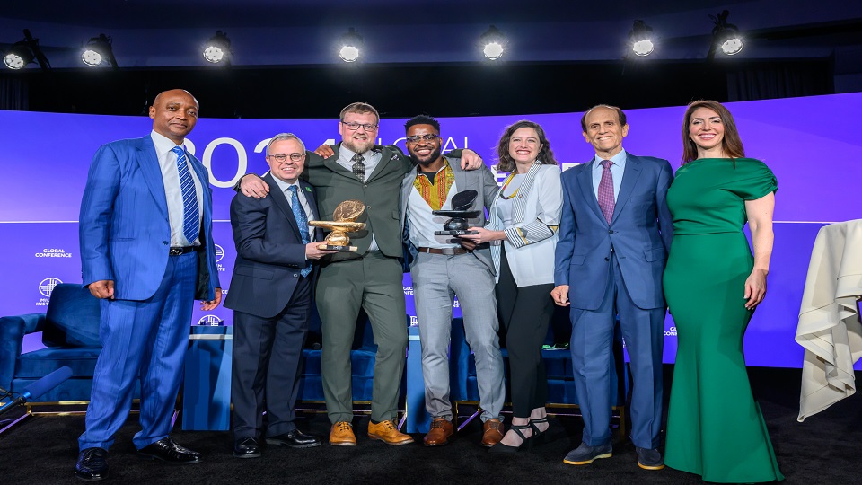 Loughborough University's Jonathan Wilson and the Consortium for Battery Innovation's Carl Telford pose with the Milken-Motsepe prize for green energy alongside other representatives.