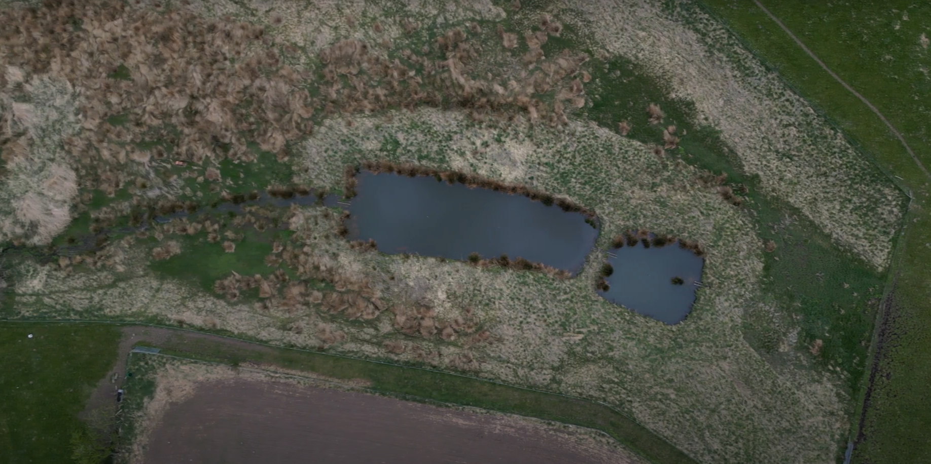 An aerial shot of dual sediment ponds - two small ponds next to each other