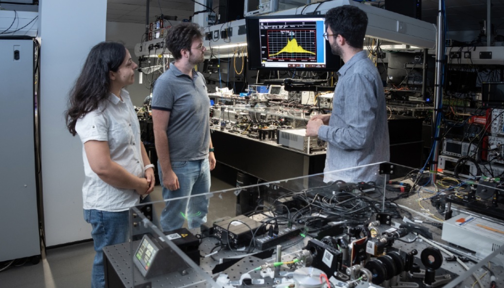 Dr Luke Peters (centre) and colleagues from Loughborough University’s Emergent Photonics Research Centre examine the precisely organised spectrum of light produced by their system, which can be converted into multiple high-frequency signals known as millimetre waves.