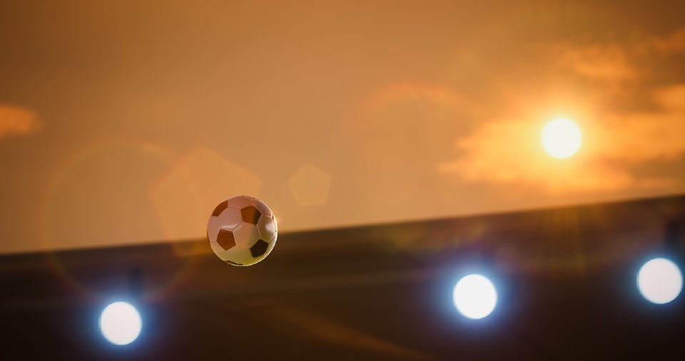 A football flying through the air with a blazing sun in the background