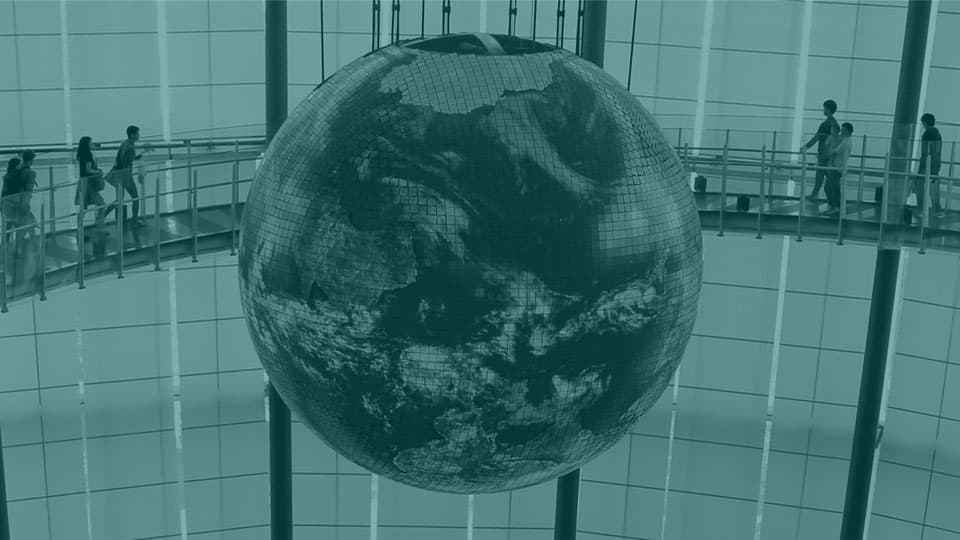 A graphic of a globe with people walking around it