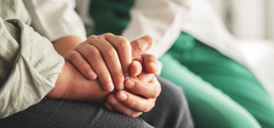 a doctor holds a patient's hand