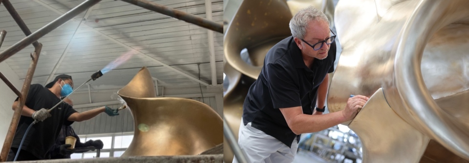 Split image showing two stages of work on a large metallic sculpture: on the left, a person wearing a mask uses a blowtorch to heat and patinate the surface; on the right, John Atkin carefully brushes and refines the gold-toned metal by hand, highlighting the detailed finishing process.