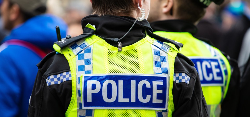 a police officer in uniform with the word police on their hi vis jacket