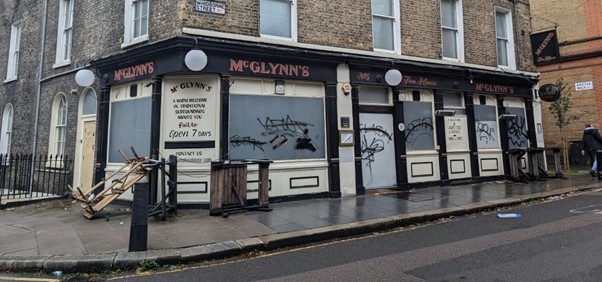 McGlynn's pub in Kings Cross, London, closed with boarded windows covered in graffiti