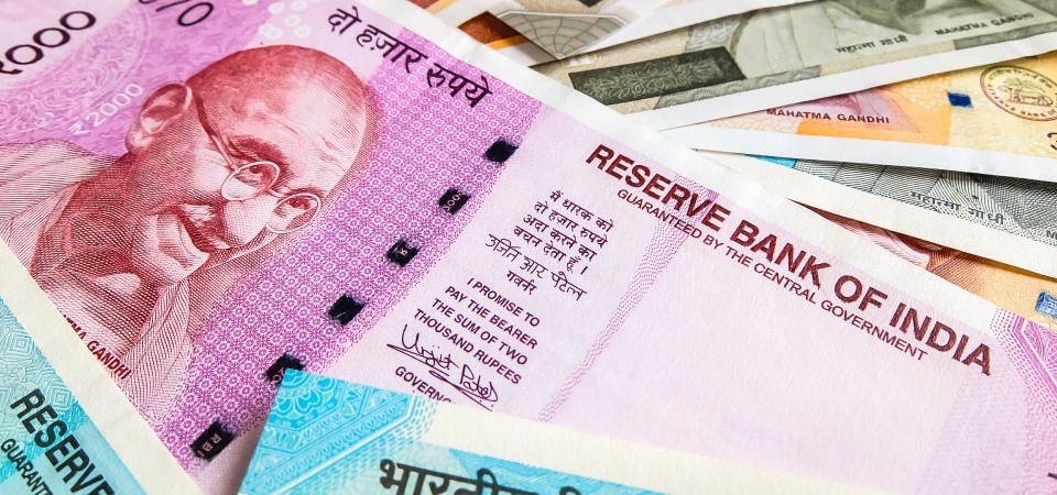Rupee notes spread out across a table